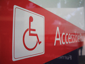 Foto - Cartello in aeroporto che indica l’accessibilità per i portatori di handicap