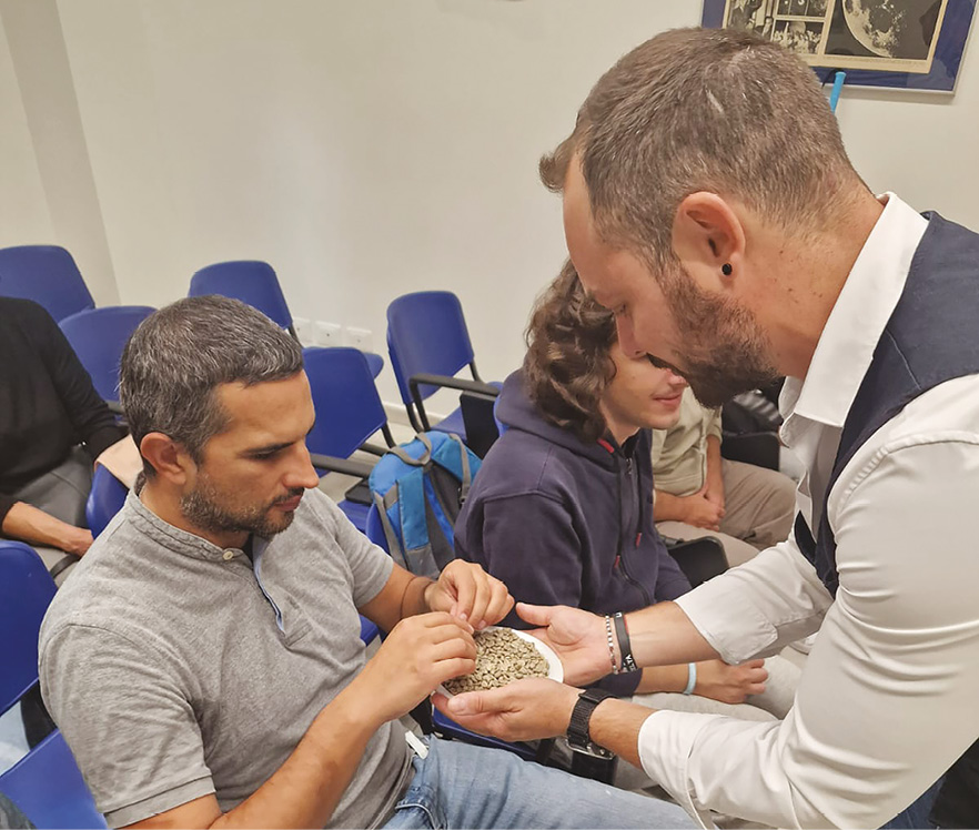 Un partecipante che tocca i chicchi di caffè guidato