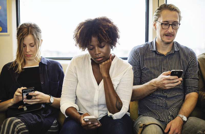 Tre persone che usano il telefonino