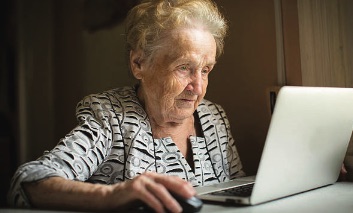 Elderly woman learning how to use a computer