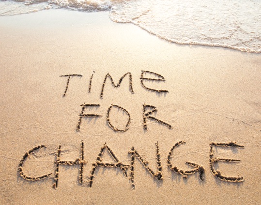 The phrase "Time for Change" written in the sand