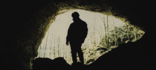 Speleologist at the entrance of a cave