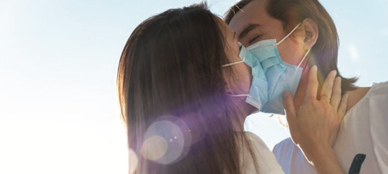 Couple kissing with masks