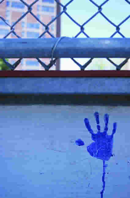 Impronta blu di una mano sul muro