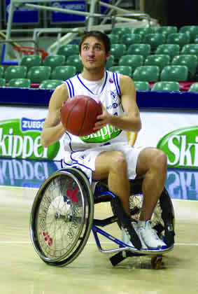 Pozzecco tries shooting the ball while sitting in the wheelchair