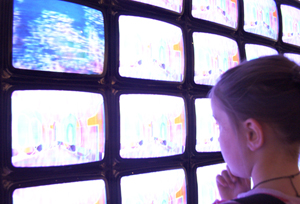 Foto di bambina che guarda dei monitor